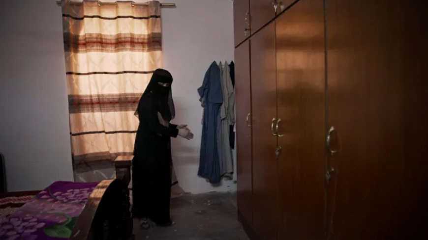 Safa inside the bedroom where her family was killed, explaining where she laid pretending to be dead 
